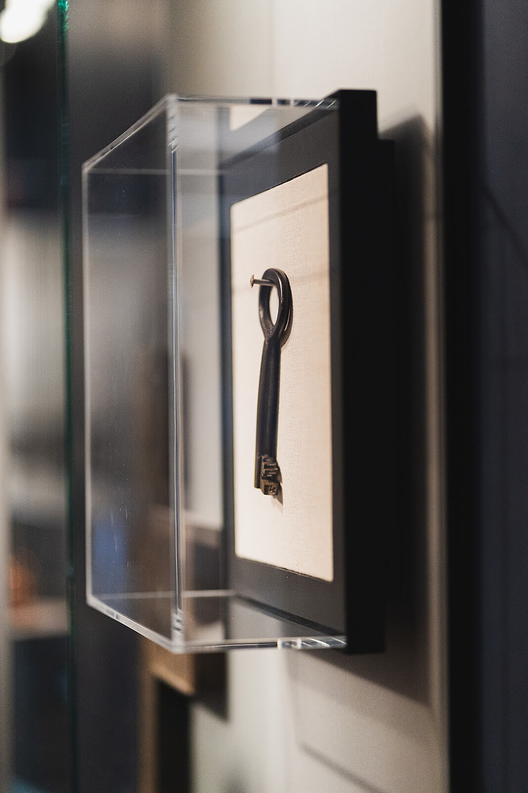 Old key in a glass box on a wall