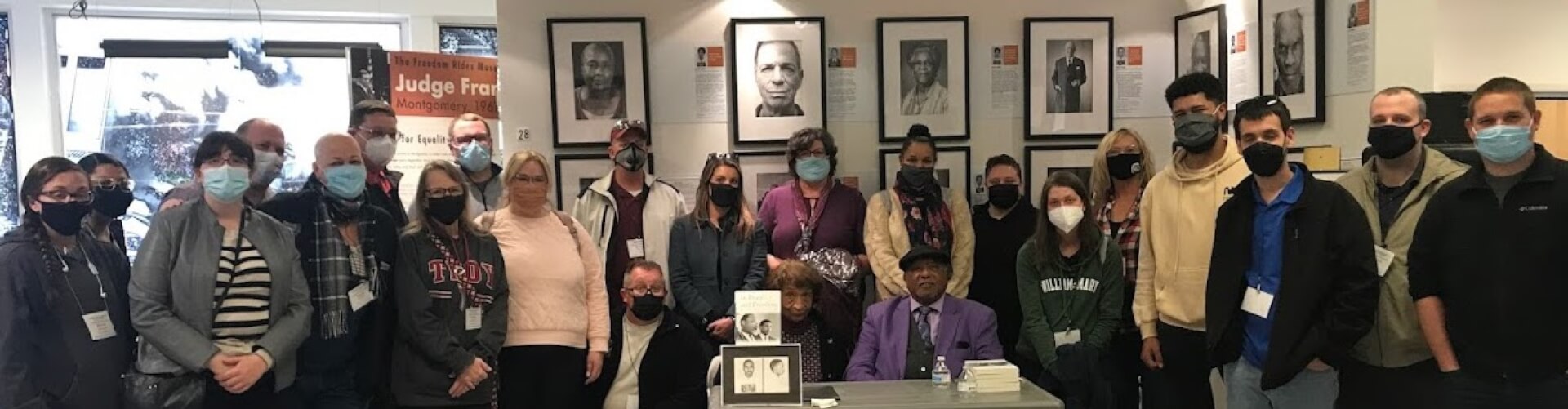Teachers with masks standing around two people at a table